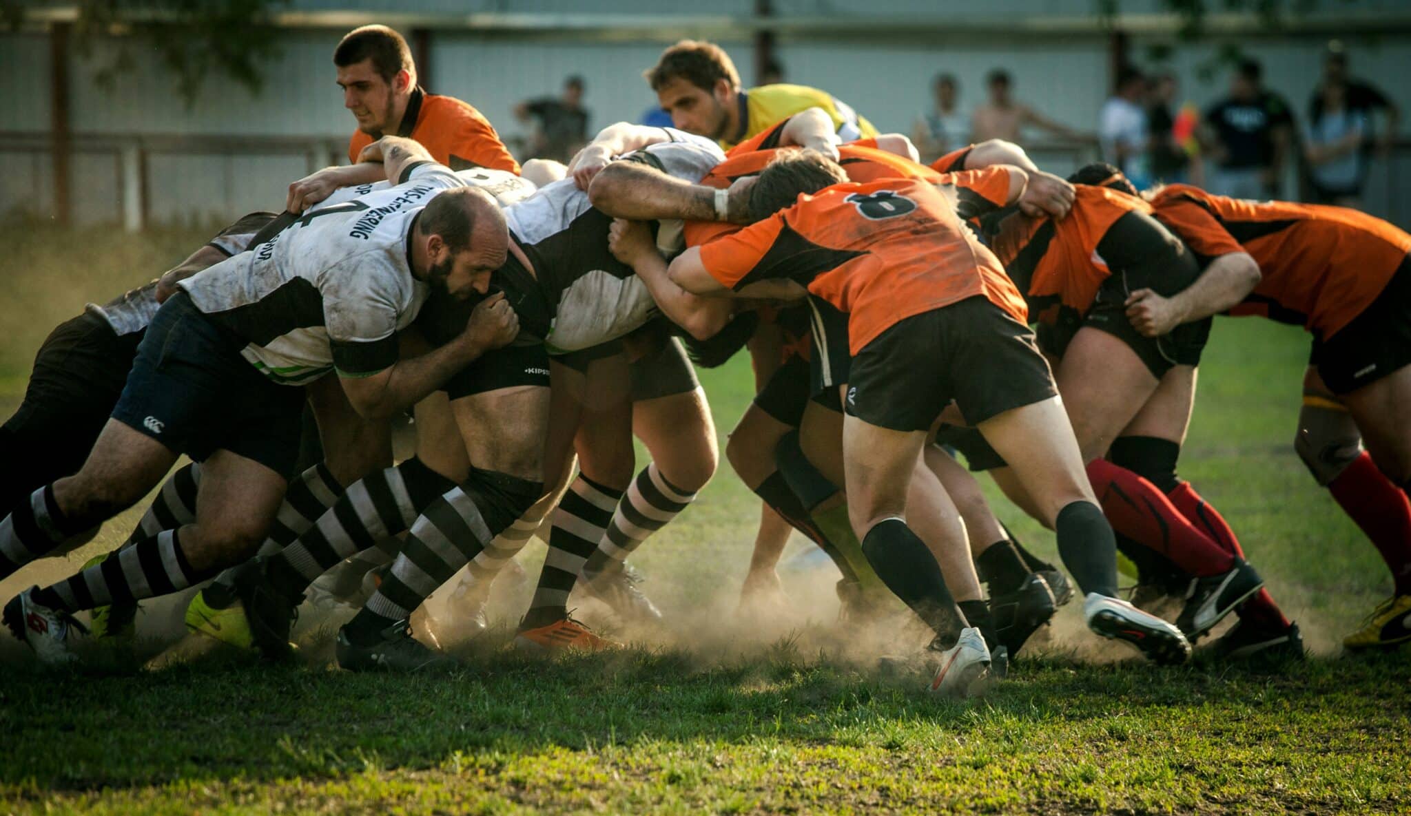 Équipes de rugby s'affrontant en mêlée.