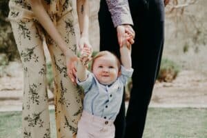 Enfant tenu par ses parents.